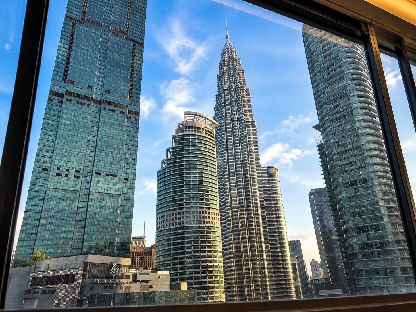 A cityscape with modern skyscrapers, including a prominent tower with a spire.