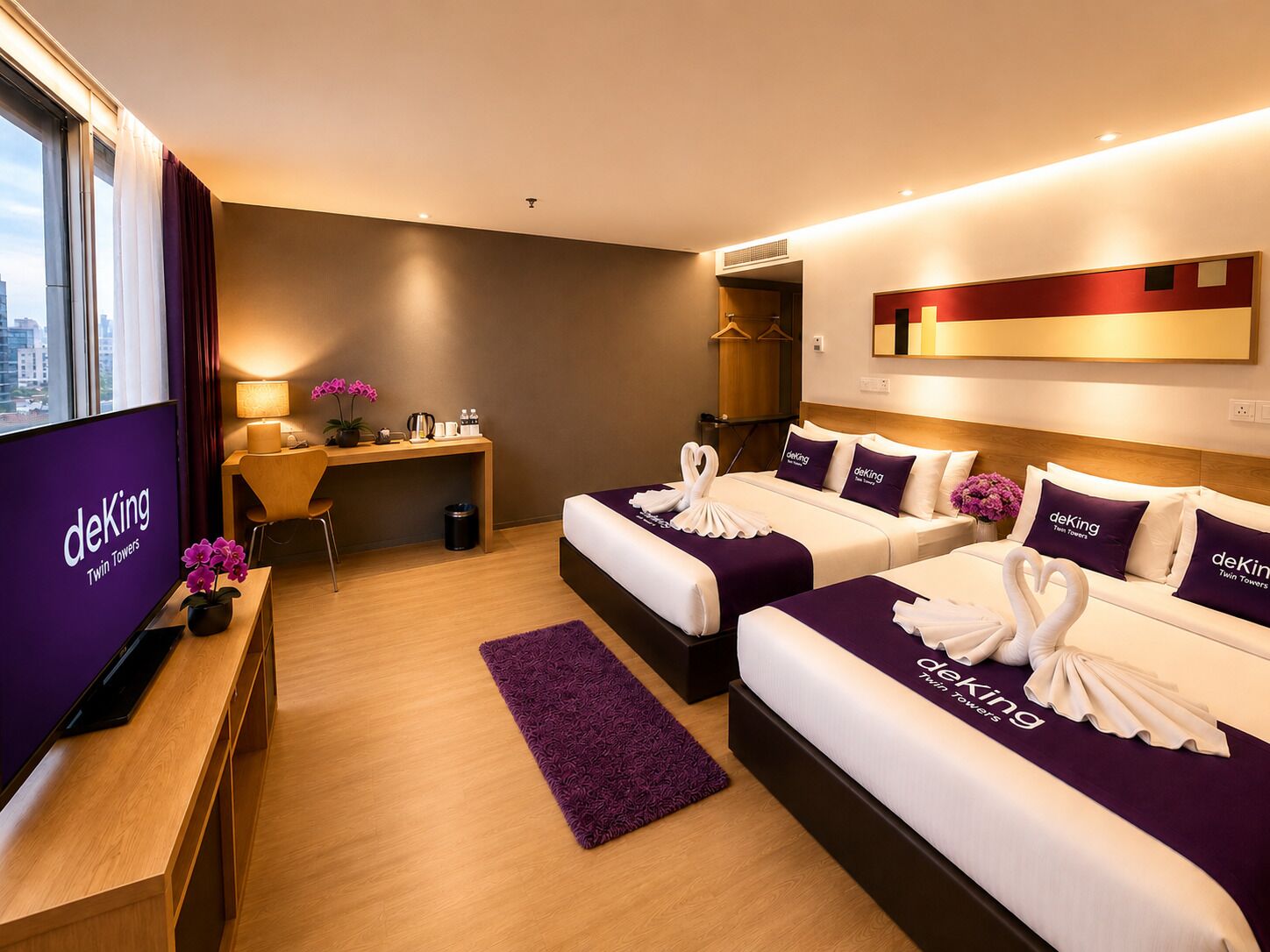 Habitación de hotel con dos camas, un escritorio, un televisor y vistas a la ciudad.