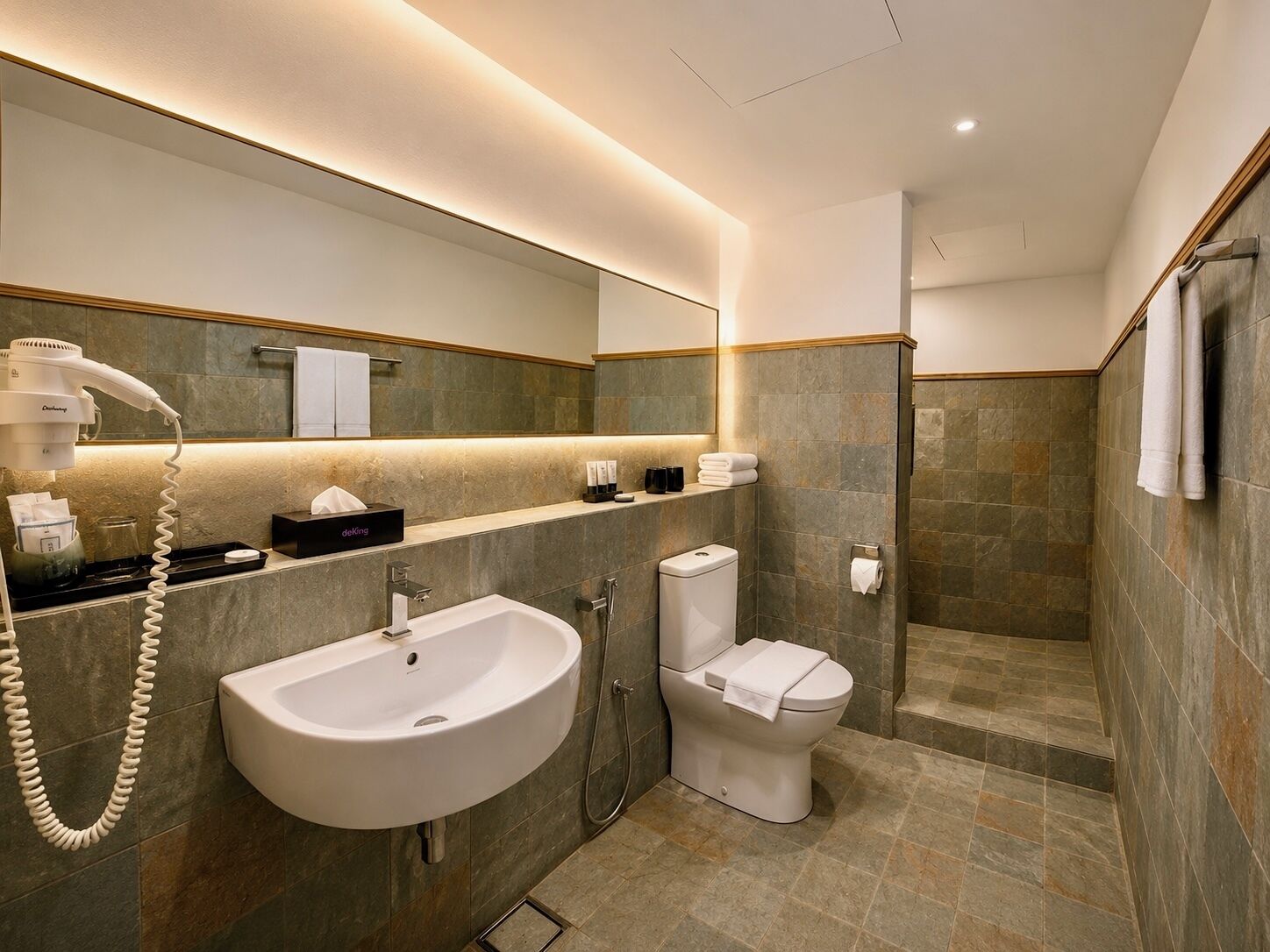 A modern bathroom with a sink, toilet, and shower.