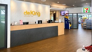 A hotel reception area with a modern design, featuring a reception desk, a 7-Eleven store, and an ATM. - deKing Hotel Twin Towers KLCC (Kuala Lumpur)