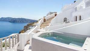 Un edificio blanco con piscina y vistas al mar.