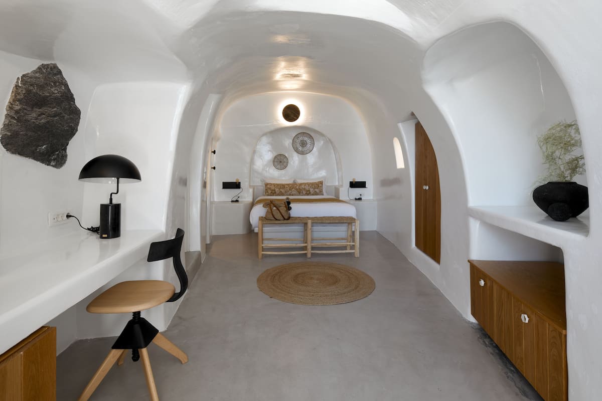 Una habitación acogedora con paredes blancas, una cama, un escritorio y una silla.