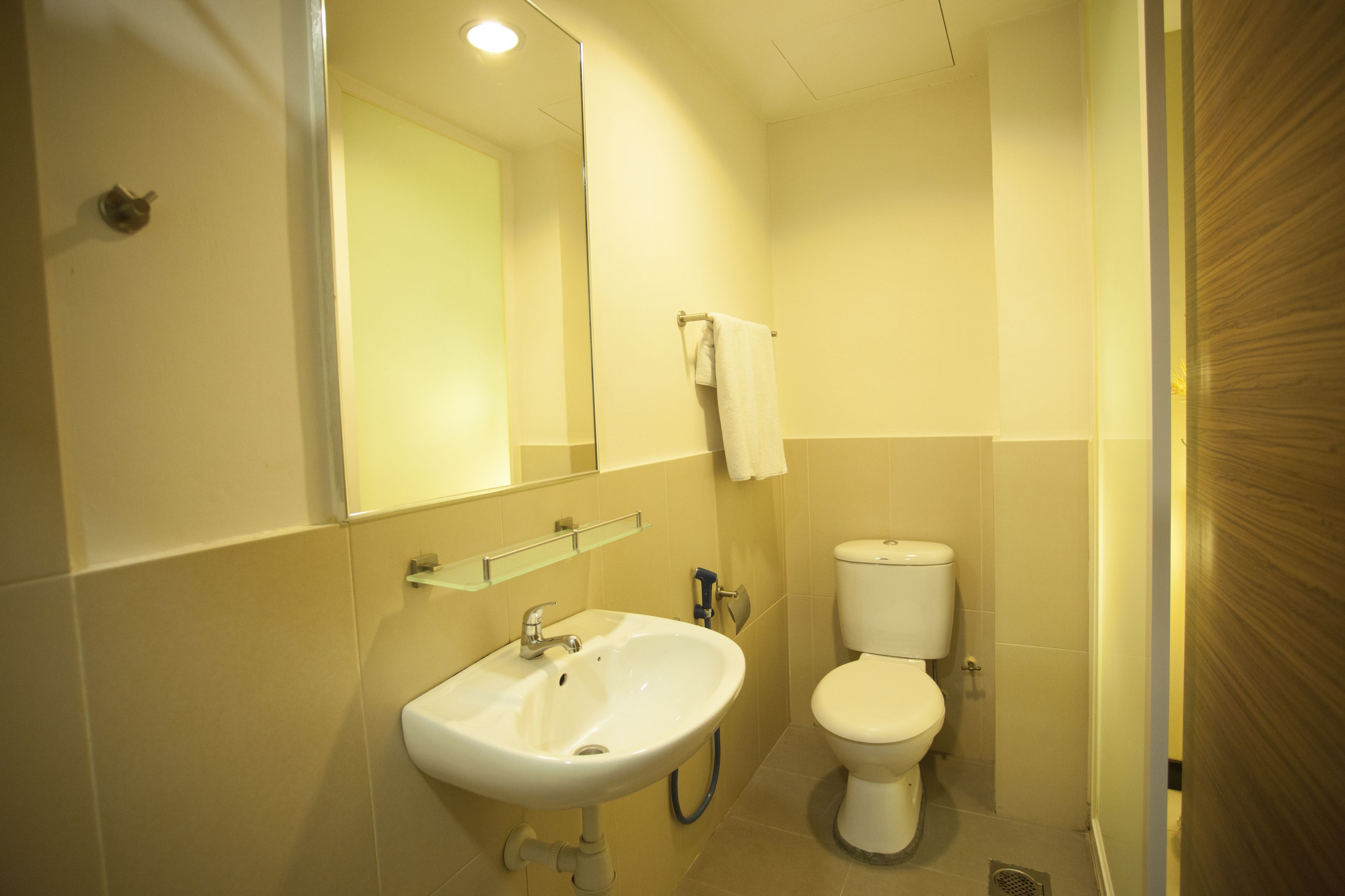 Een kleine badkamer met een wastafel, spiegel en toilet.