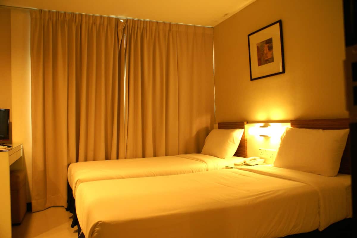 Een hotelkamer met een bed, een bureau en een telefoon.