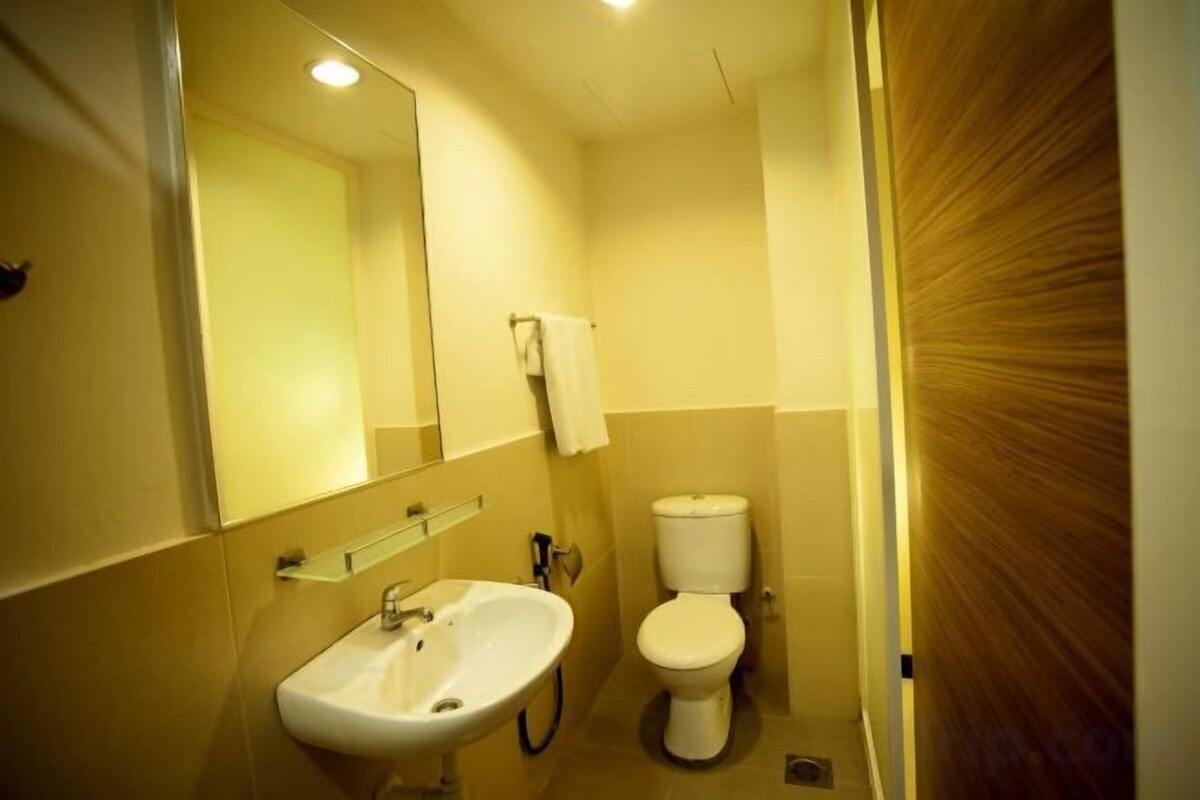 A bathroom with a sink, mirror, and toilet.