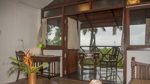 A room with a wooden table, chairs, a small desk, and a window with curtains. - Over The Hill (Neyyattinkara)