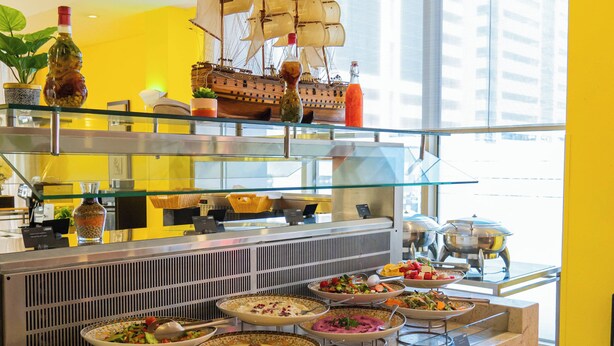 A buffet area with various food dishes and a ship decoration on the counter. - Copthorne Downtown Abu Dhabi (Abu Dhabi)