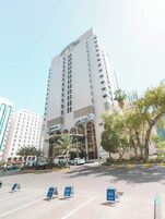 Un edificio de hotel alto con diseño moderno, que presenta una entrada y señalización destacadas.