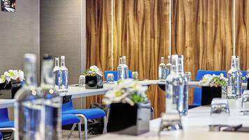 A conference room with long tables, chairs, and water bottles.