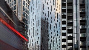 A modern urban street with tall buildings, including a distinctive triangular structure and a curved building. - Montcalm East, Autograph Collection (London)