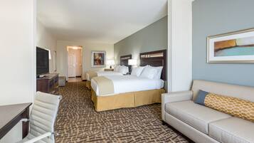 Ein Hotelzimmer mit Bett, Sofa, Schreibtisch und Fernseher.
