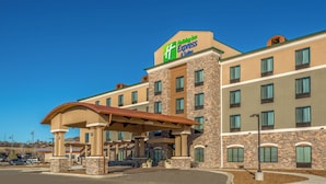 Un hôtel Holiday Inn Express & Suites avec une façade en briques, de nombreuses fenêtres et une entrée abritée.
