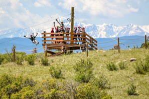 A group of people on a zip line with a mountainous backdrop. - Holiday Inn Express & Suites Denver South - Castle Rock by IHG (Castle Rock)