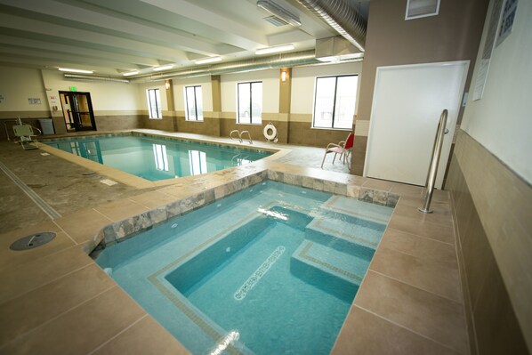 An indoor swimming pool with clear water, tiled walls, and a lifeguard chair. - Holiday Inn Express & Suites Denver South - Castle Rock by IHG (Castle Rock)