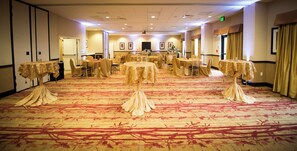 A banquet hall with round tables and chairs, carpeted floor, and framed pictures on the walls. - Holiday Inn Express & Suites Denver South - Castle Rock by IHG (Castle Rock)