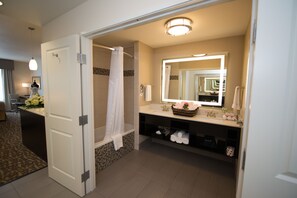 A modern bathroom with a shower, a vanity with a large mirror, and a towel rack. - Holiday Inn Express & Suites Denver South - Castle Rock by IHG (Castle Rock)