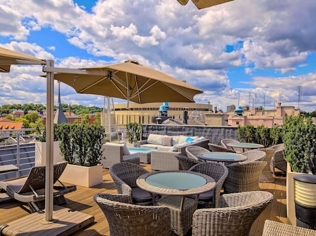 A rooftop terrace with wicker furniture, a pool table, and a large umbrella.. Mercure Bydgoszcz Sepia