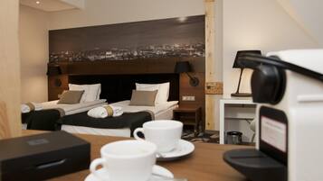A hotel room with two beds, a cityscape view, a coffee machine, and a table with a cup and saucer.
