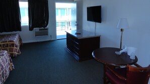A hotel room with a bed, a desk, a chair, a TV, and a window with curtains. - Travel Inn (North Hills)