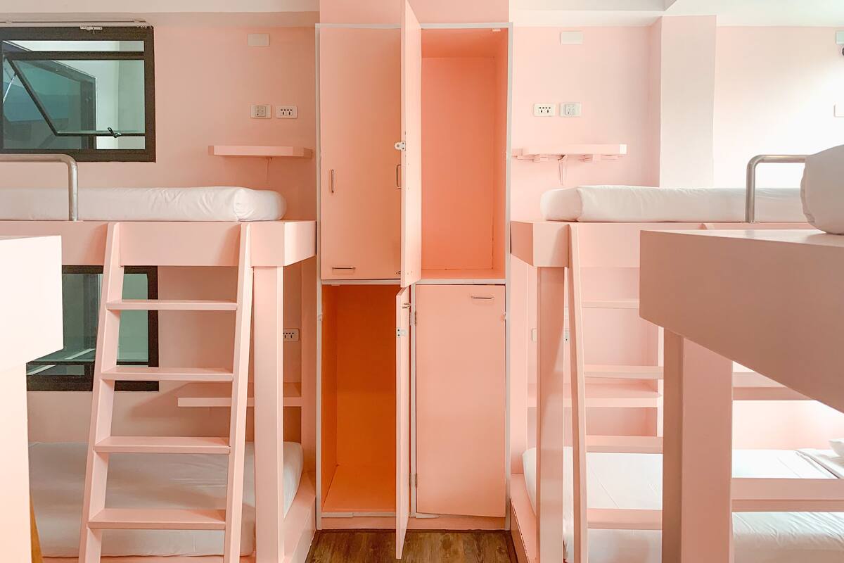 A compact room with bunk beds, a small kitchenette, and a window.