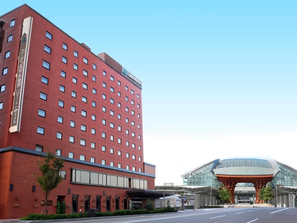 A red brick hotel with multiple floors and a large glass entrance structure.