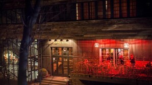 Un hôtel à la façade moderne, doté de grandes fenêtres et d’une entrée illuminée de lumière rouge.