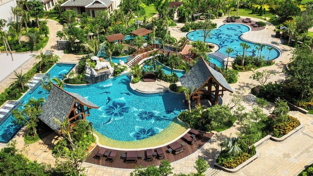 A resort with multiple swimming pools, a bridge, and a variety of outdoor seating areas. - Haikou Marriott Hotel (Haikou)