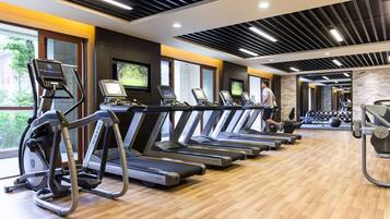 A gym with treadmills, exercise bikes, and weights.