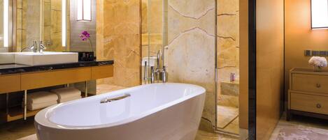 A modern bathroom with a freestanding bathtub, a double sink vanity, and a large mirror.