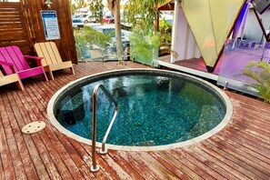 A small, round outdoor pool with a metal ladder, surrounded by wooden decking and colorful chairs. - North Gregory Hotel (Winton)