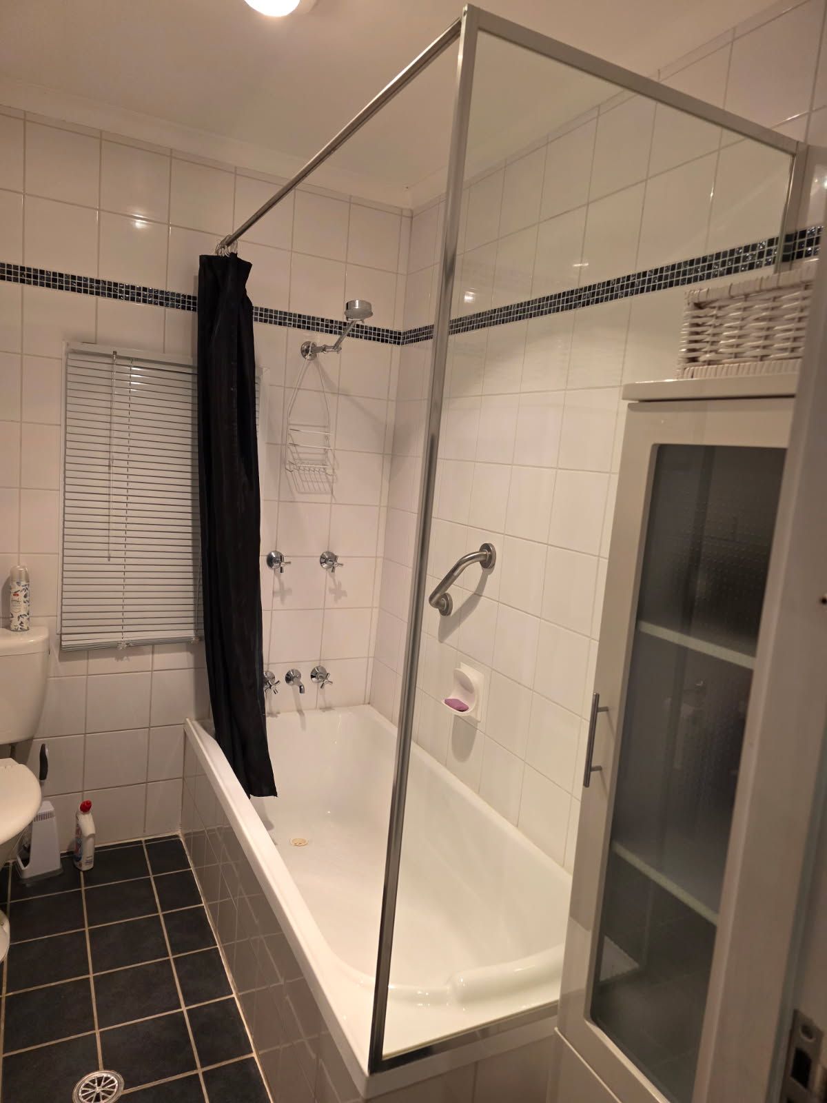 Een moderne badkamer met een douchecabine van glas, een badkuip en een toilet.