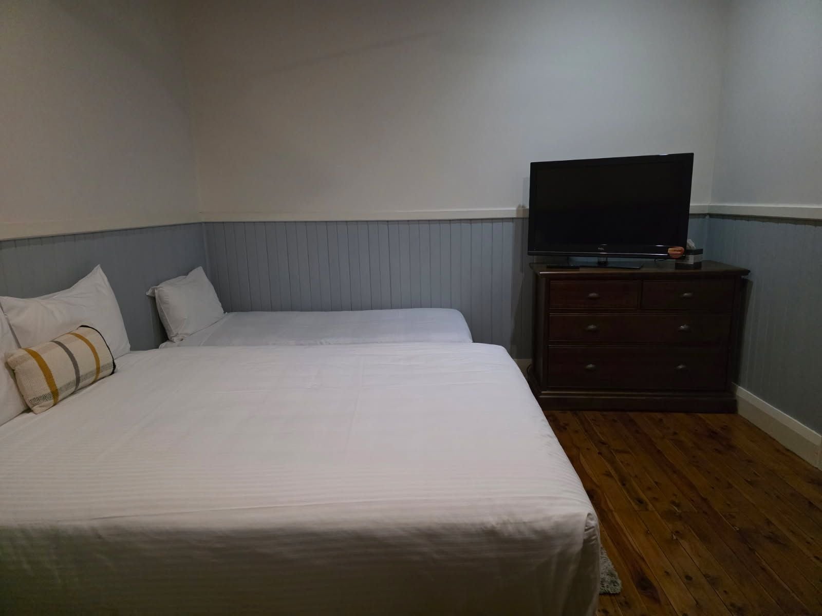 Une chambre d’hôtel avec un lit, une commode et un téléviseur.