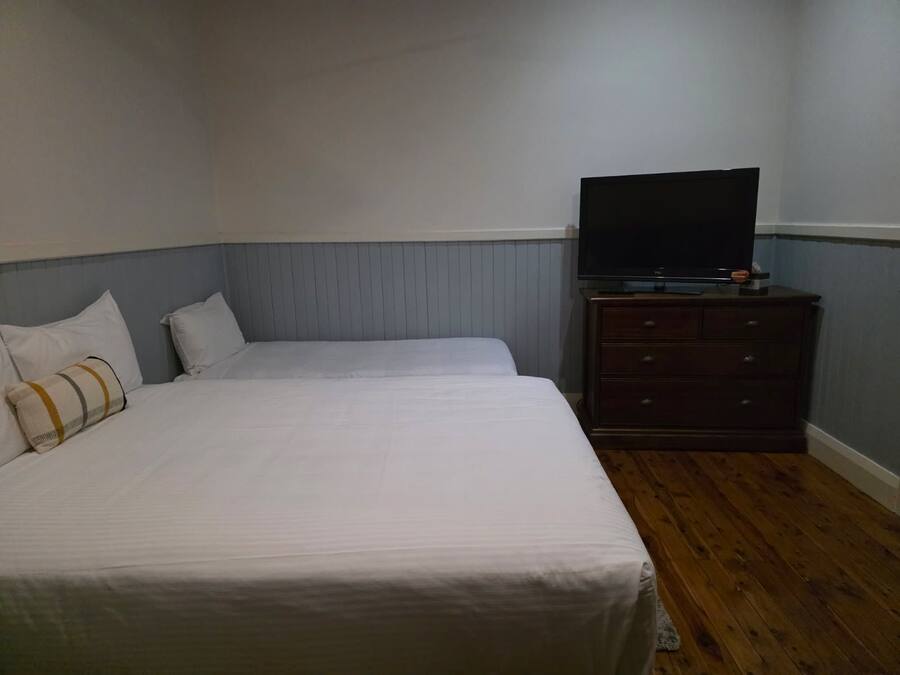 Une chambre d’hôtel avec un lit, une commode et un téléviseur.