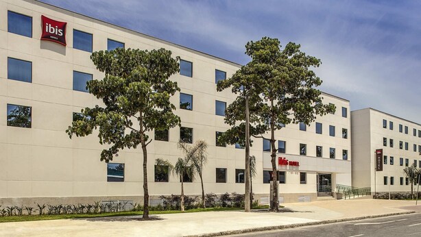 A modern hotel building with multiple windows and a prominent 'ibis' sign. - Ibis Rio de Janeiro Parque Olimpico (Rio de Janeiro)