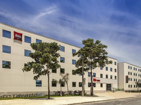 A modern hotel building with multiple windows and a prominent 'ibis' sign. - Ibis Rio de Janeiro Parque Olimpico (Rio de Janeiro)