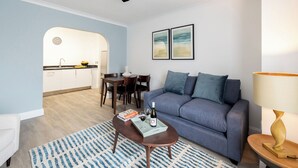 Una sala de estar con sofá, una mesa de centro y un comedor con sillas y una mesa.