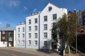 A multi-story building with a flat facade, several windows, and a small entrance. - SACO Jersey Merlin House (St. Helier)