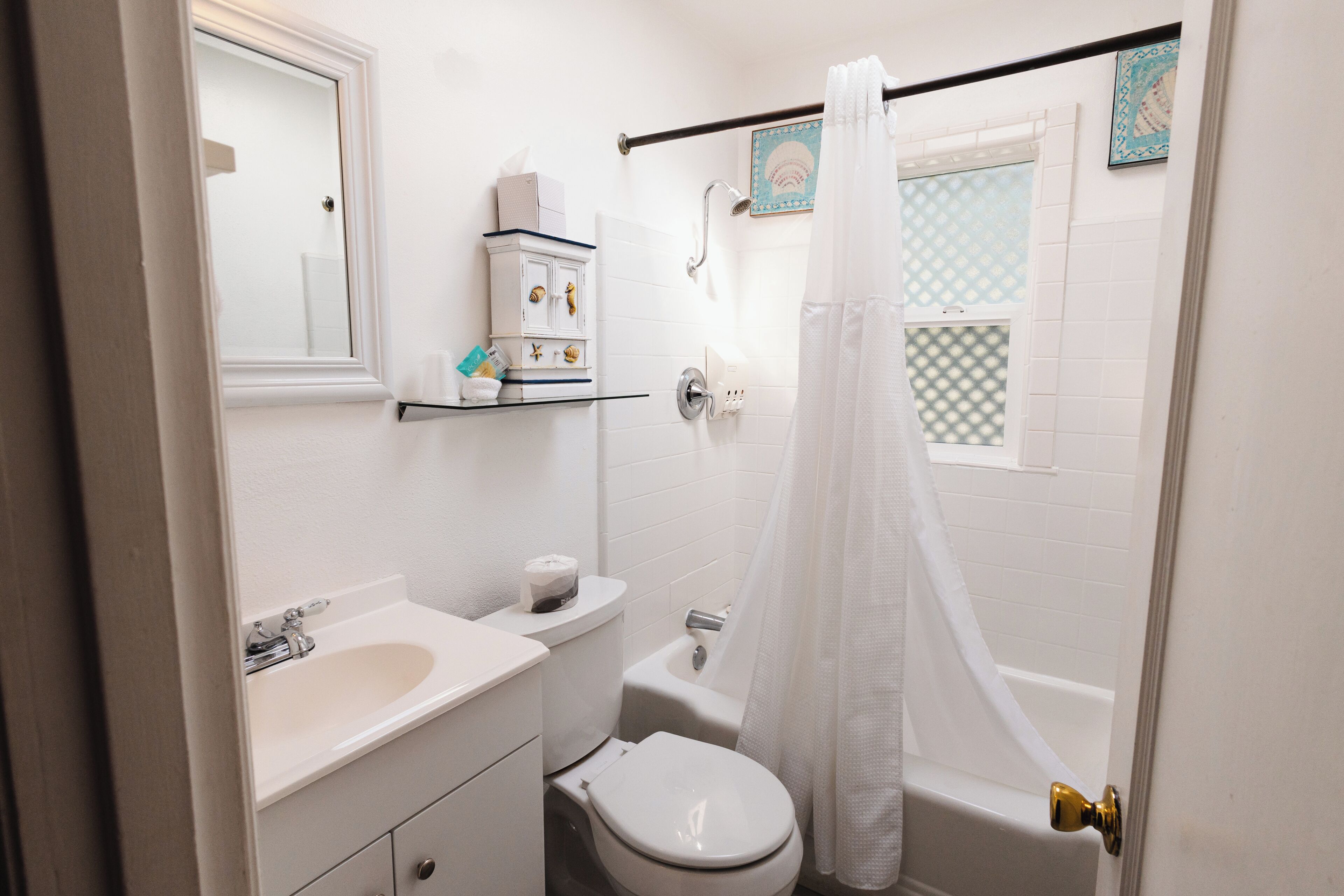 A bathroom with a toilet, sink, and shower curtain.