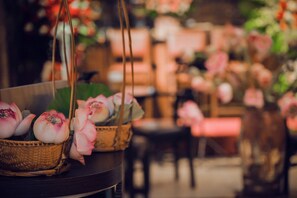 Una cesta de mimbre con flores de loto rosadas sobre una mesa.