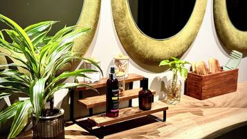 A wooden shelf with a potted plant, a bottle of Karse, and a wooden box with brushes.