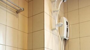 A bathroom with a toilet, a shower, and a toilet paper holder. - Cheeky Monkey's Samui (Koh Samui)