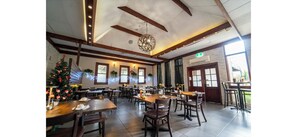A spacious dining area with wooden tables and chairs, a Christmas tree, and large windows allowing natural light. - Nowra Motor Inn (Nowra)