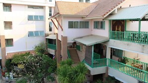 A multi-story residential building with balconies, a staircase, and a small outdoor seating area. - Tamarind Residences (Khon Kaen)