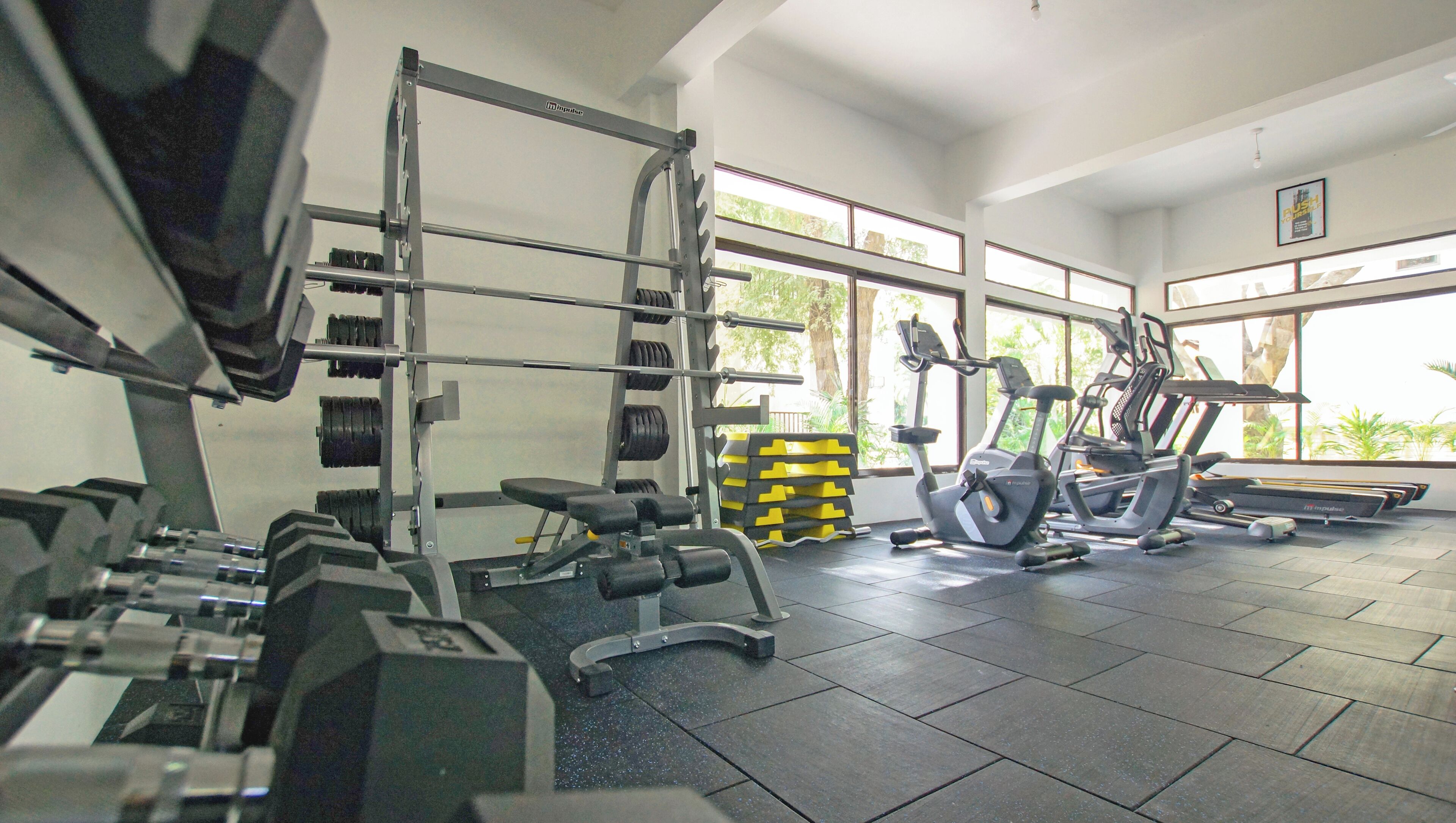 A gym with weightlifting equipment, treadmills, and exercise bikes.