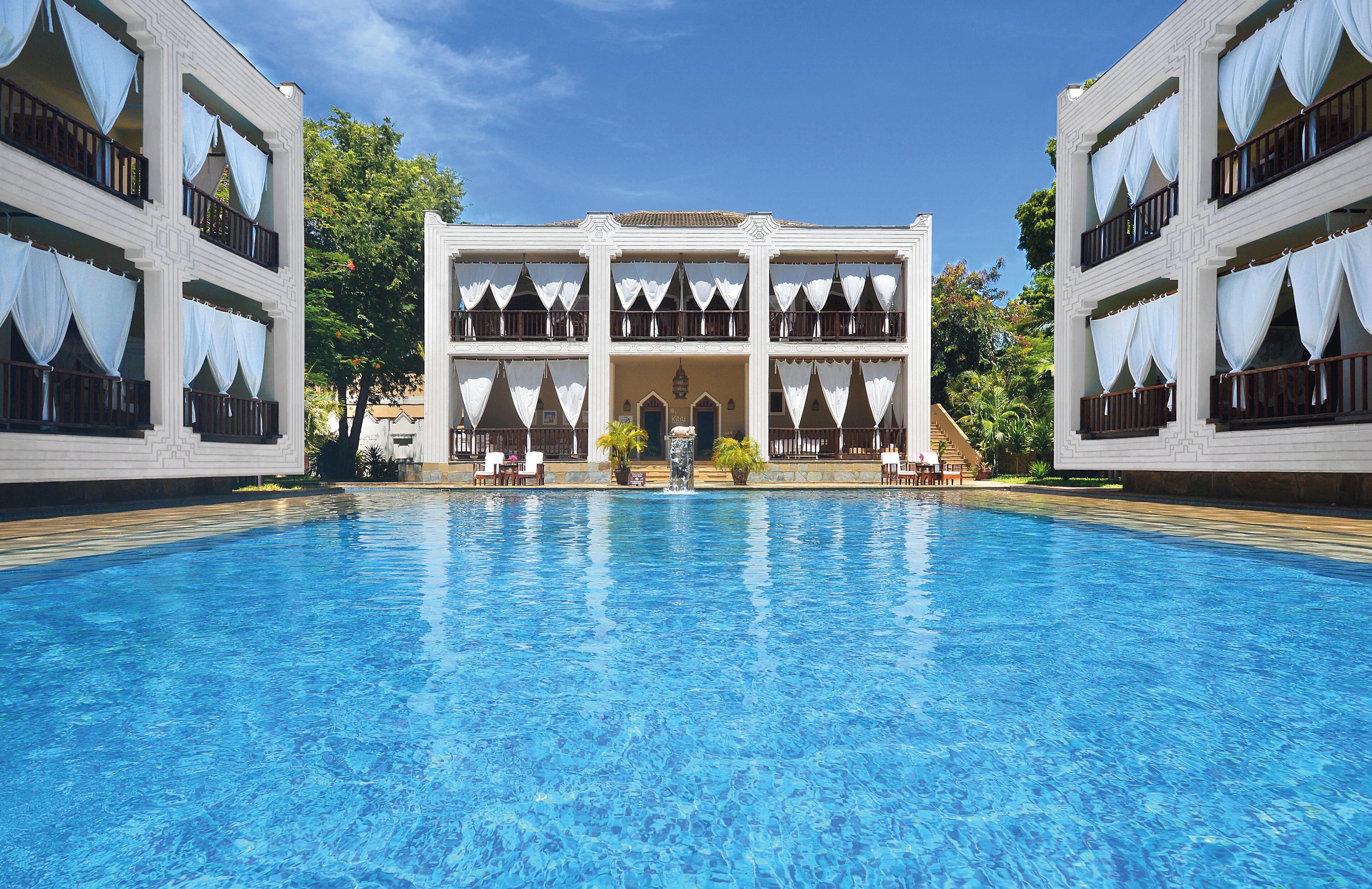 Una piscina grande con un edificio al fondo.