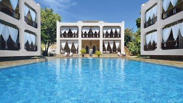 Uma piscina grande com um edifício ao fundo.
