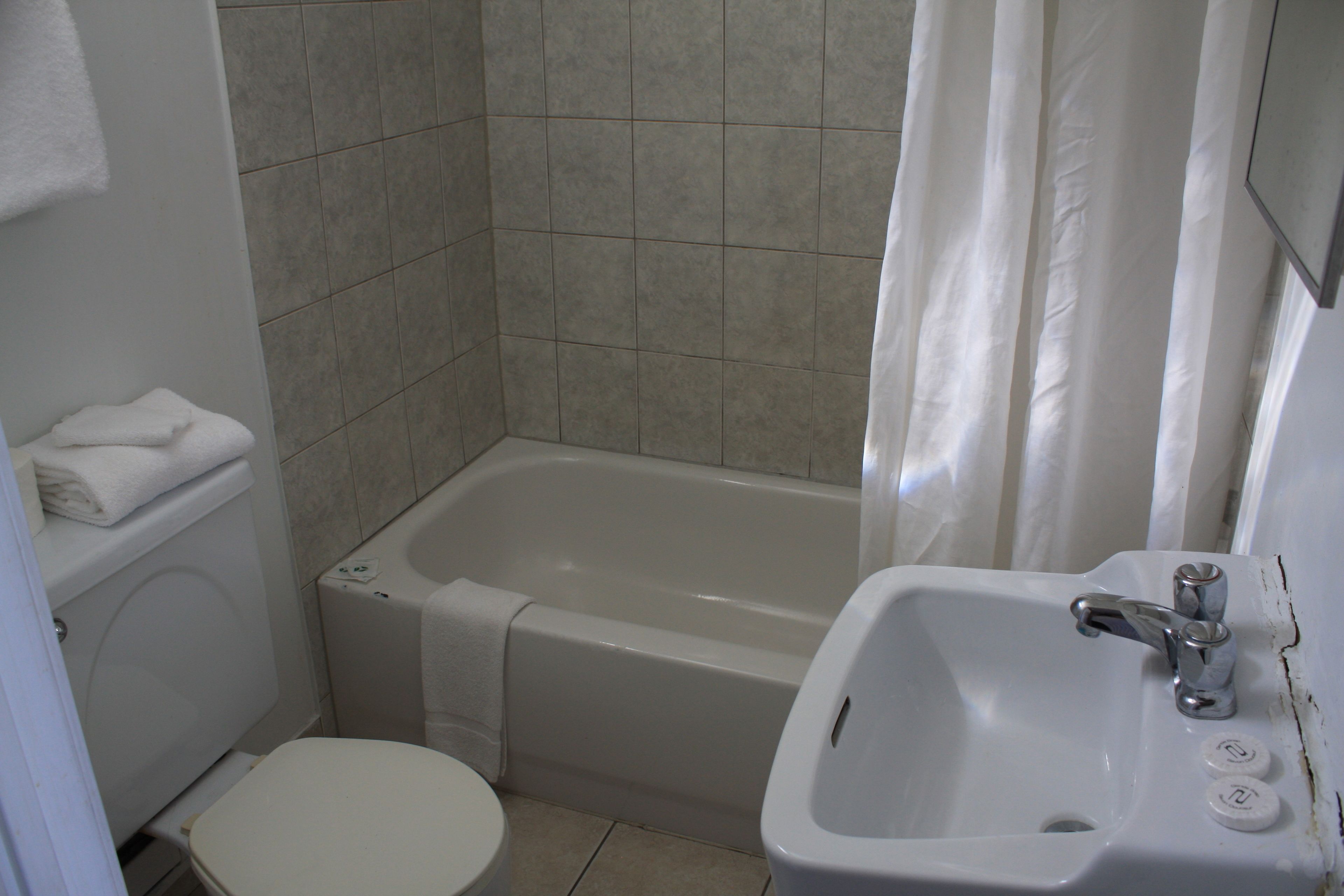 A small bathroom with a toilet, a sink, and a bathtub.