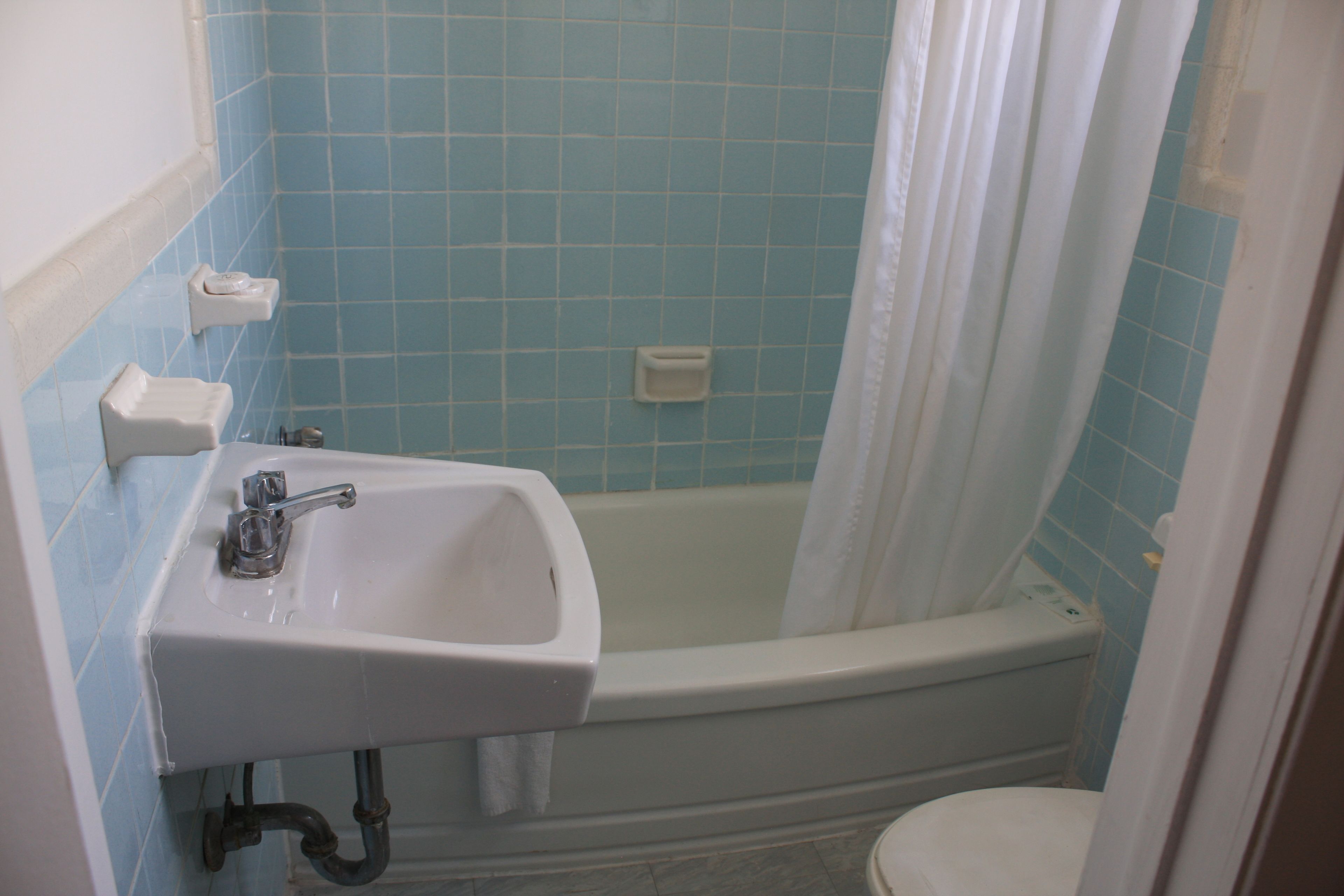 Un bagno con un lavandino bianco, una vasca e un WC.
