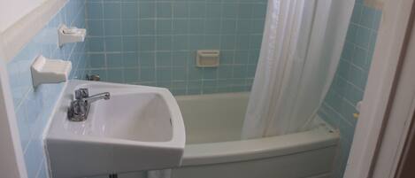 Un bagno con un lavandino bianco, una vasca e un WC.