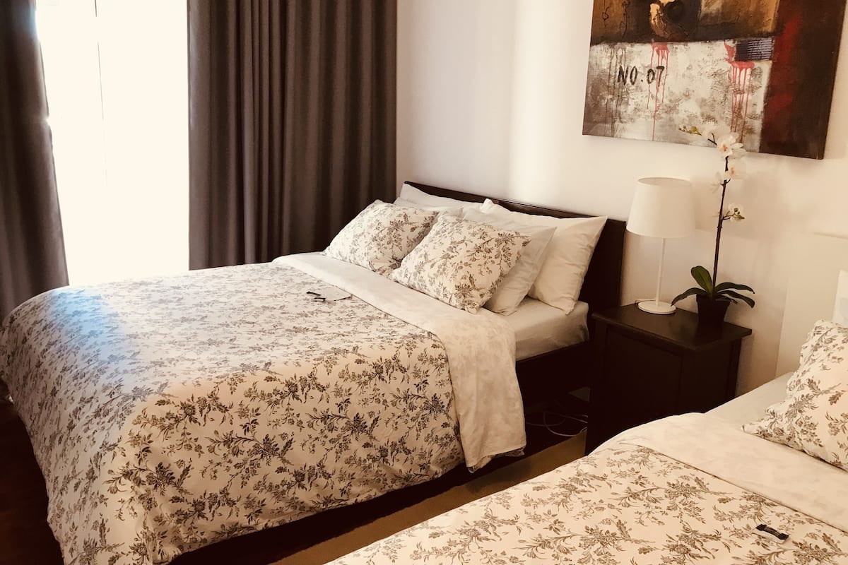 Une chambre d’hôtel avec un grand lit, une table de chevet avec une lampe et un tableau au mur.